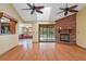 Bright living room featuring a brick fireplace, skylight, ceiling fans, and sliding doors to the pool at 8402 Lake Hill Ct, Spring Hill, FL 34608