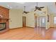 Inviting living room featuring a brick fireplace, ceiling fans, and view of the front entryway at 8402 Lake Hill Ct, Spring Hill, FL 34608