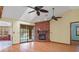 Open living area with brick fireplace, sliding glass doors to the pool, and wood-look flooring at 8402 Lake Hill Ct, Spring Hill, FL 34608