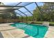 A refreshing screened-in pool with clear water and a waterfall feature at 8402 Lake Hill Ct, Spring Hill, FL 34608
