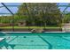 Beautiful screened-in pool with a tranquil waterfall and spacious backyard at 8402 Lake Hill Ct, Spring Hill, FL 34608