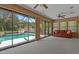 Inviting sunroom with a comfortable sofa and serene views of the screened-in pool at 8402 Lake Hill Ct, Spring Hill, FL 34608