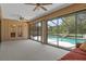 Bright sunroom with ceiling fans, large windows, and a view of the sparkling screened-in pool at 8402 Lake Hill Ct, Spring Hill, FL 34608
