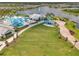 Aerial view of a community clubhouse, pool, stage area, lake, and manicured landscaping at 8431 Ocean Tides Cv, Parrish, FL 34219