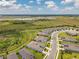 Aerial view of a modern residential community with well-manicured lawns and paved streets, near green space at 8431 Ocean Tides Cv, Parrish, FL 34219