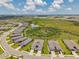 Panoramic aerial view of a community featuring modern homes surrounding a pond and green space at 8431 Ocean Tides Cv, Parrish, FL 34219