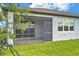 Exterior showing a screened lanai and well-manicured backyard with lush greenery at 8431 Ocean Tides Cv, Parrish, FL 34219
