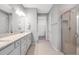 Bright bathroom featuring a double vanity with a granite countertop and a glass-enclosed shower at 8431 Ocean Tides Cv, Parrish, FL 34219