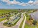 Aerial view of the community entrance with water feature, palm trees, and a US flag at 8431 Ocean Tides Cv, Parrish, FL 34219
