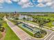 Aerial view of the community entryway with a water feature, American flag, lake and fountain at 8431 Ocean Tides Cv, Parrish, FL 34219