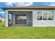 View of the home's exterior showcasing the screened lanai and green lawn at 8431 Ocean Tides Cv, Parrish, FL 34219