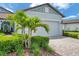 Charming garage with lush landscaping and a brick paver driveway with beautiful curb appeal on a sunny day at 8431 Ocean Tides Cv, Parrish, FL 34219
