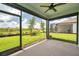 Relaxing screened lanai with ceiling fan overlooking the lush green backyard at 8431 Ocean Tides Cv, Parrish, FL 34219