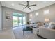 Bright living room featuring neutral tones, ceiling fan, and sliding glass doors to outdoor space at 8431 Ocean Tides Cv, Parrish, FL 34219