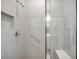 Modern shower with a built-in seat, grab bar, and tiled wall at 8431 Ocean Tides Cv, Parrish, FL 34219