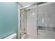 Close-up of shower-tub combo with sleek, sliding doors and standard shower head in a white-tiled enclosure at 9212 Estrada Pl, New Port Richey, FL 34655