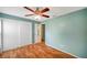 Bedroom featuring a ceiling fan and sliding door closet with access to ensuite at 9212 Estrada Pl, New Port Richey, FL 34655
