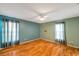 Spacious primary bedroom boasts natural light, wood-look floors, and a ceiling fan at 9212 Estrada Pl, New Port Richey, FL 34655