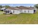 Rear exterior view of a home showcasing a sunroom addition and well-maintained lawn space at 9212 Estrada Pl, New Port Richey, FL 34655