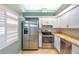 Bright kitchen featuring stainless steel appliances, white cabinets, and stone countertops at 9212 Estrada Pl, New Port Richey, FL 34655