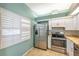 Bright kitchen featuring stainless steel appliances, white cabinets, and stone countertops at 9212 Estrada Pl, New Port Richey, FL 34655