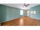 Bright and spacious living room with wood floors, a ceiling fan and a pass-through window to the kitchen at 9212 Estrada Pl, New Port Richey, FL 34655