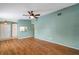 Bright and spacious living room with wood floors, a ceiling fan and a pass-through window to the kitchen at 9212 Estrada Pl, New Port Richey, FL 34655