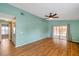 Spacious living room with wood floors, ceiling fan and sliding glass doors to an enclosed lanai at 9212 Estrada Pl, New Port Richey, FL 34655