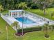 Community pool area with ample seating, a covered pavilion, palm trees and an American flag at 9212 Estrada Pl, New Port Richey, FL 34655