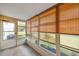 Enclosed sunroom with bright windows and wood blinds offering a peaceful space with views of the outdoors at 9212 Estrada Pl, New Port Richey, FL 34655