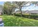 Manicured backyard showcasing a lush lawn, verdant hedges, and mature trees providing ample shade at 9334 Whitstone Ct, New Port Richey, FL 34655