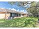 Expansive backyard featuring a well-maintained lawn and screened porch with shade trees at 9334 Whitstone Ct, New Port Richey, FL 34655