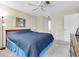 Bright bedroom with ceiling fan, blue bedspread, and closet at 9334 Whitstone Ct, New Port Richey, FL 34655