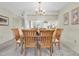 Cozy dining room with wood table, chairs, and chandelier open to the kitchen for easy serving at 9334 Whitstone Ct, New Port Richey, FL 34655