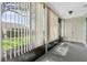 Enclosed sunroom with verdant outdoor views, vertical blinds, neutral tones, and convenient closet storage at 9334 Whitstone Ct, New Port Richey, FL 34655