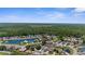 Vibrant aerial view displays homes surrounding a beautiful lake and green trees on the horizon at 9407 Burnam Dr, Weeki Wachee, FL 34613