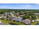 Wide aerial shot showcases the neighborhood's layout, lush landscaping, ponds, and a dense tree line at 9407 Burnam Dr, Weeki Wachee, FL 34613