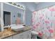 Bright bathroom features a flamingo shower curtain, a vessel sink with granite countertop and blue walls at 9407 Burnam Dr, Weeki Wachee, FL 34613