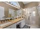 Bright bathroom with double sinks, granite countertops, a large mirror, and a glass-enclosed shower at 9407 Burnam Dr, Weeki Wachee, FL 34613