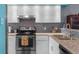 Updated kitchen with white cabinets, granite countertops, stainless steel appliances, and stylish backsplash at 9407 Burnam Dr, Weeki Wachee, FL 34613
