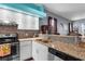 Modern kitchen with stainless steel appliances, granite countertops, and a stylish mosaic backsplash at 9407 Burnam Dr, Weeki Wachee, FL 34613