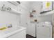 Functional laundry room with a washing machine, dryer, sink, and ample storage shelving at 9407 Burnam Dr, Weeki Wachee, FL 34613
