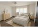 Staged bedroom with neutral colored walls, a bed with white and beige bedding, and minimalist decor at 9444 Loras St, New Port Richey, FL 34654