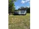 Exterior view of home with green lawn and mature trees in a country setting at 9444 Loras St, New Port Richey, FL 34654