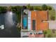 Aerial shot of the fenced-in pool, brick patio, boat dock, and home at 9810 San Sebastian Way, Port Richey, FL 34668