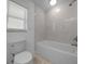Bright bathroom with a shower/tub combo, tiled wall, and a toilet at 9810 San Sebastian Way, Port Richey, FL 34668