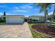 Charming home with a well-manicured lawn, brick driveway, and mature palm trees at 9810 San Sebastian Way, Port Richey, FL 34668