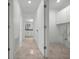Hallway with a view of a bathroom and a utility room featuring storage cabinets at 9810 San Sebastian Way, Port Richey, FL 34668
