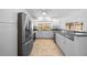 Bright kitchen features white cabinets, stainless steel appliances, and granite countertops at 9810 San Sebastian Way, Port Richey, FL 34668