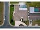 Aerial view showcases a home's roof, driveway, screened-in pool, and manicured landscaping at 10111 Glen Moor Ln, Port Richey, FL 34668